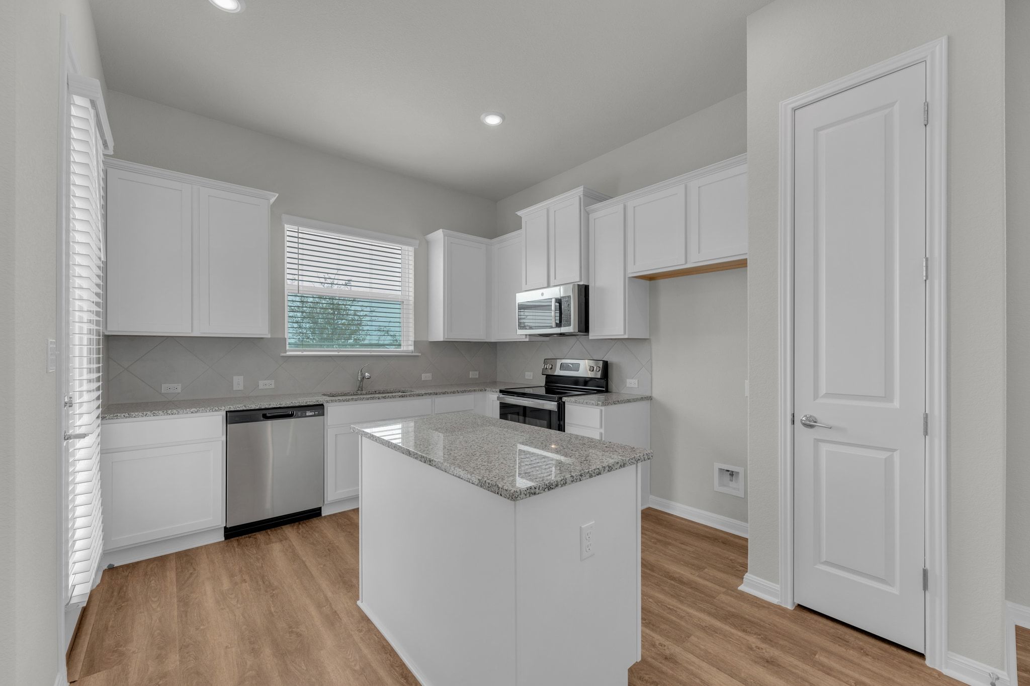 1015 Vista View Drive, Unit 101 Georgetown, TX 78626 - Photo 8 of 40 Kitchen featuring white cabinets, light stone countertops, stainless steel appliances, light wood finished floors, and recessed lighting