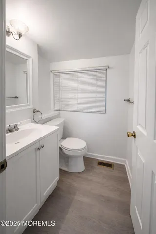 a spacious bathroom with a toilet sink and mirror