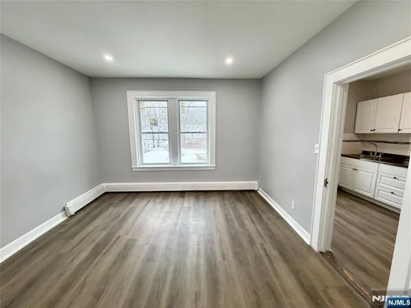 a view of a kitchen with a sink wooden floor and cabinets