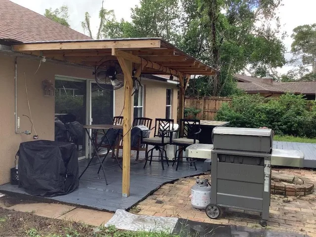 a view of a patio with table and chairs with wooden floor and fence