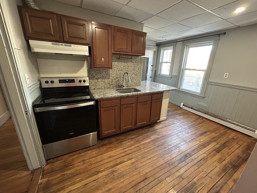 310 Park Worcester Ma, Unit 1 Worcester, MA 01609 - Photo 4 of 11 a kitchen with wooden floors and stainless steel appliances