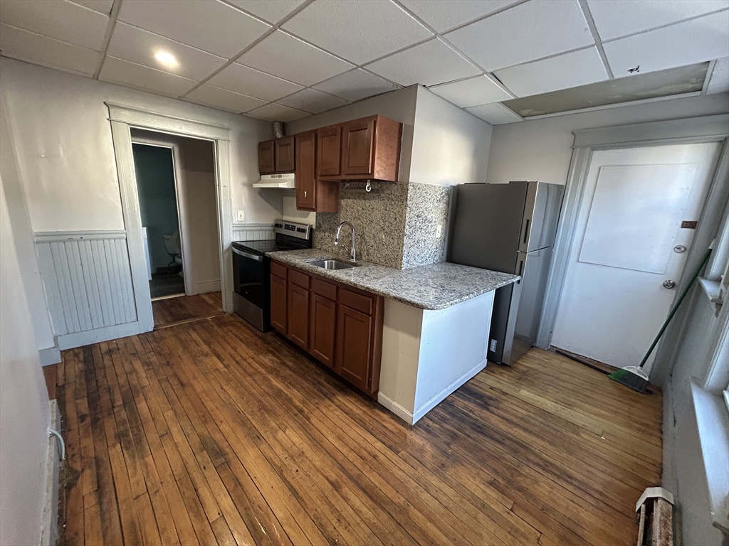 310 Park Worcester Ma, Unit 1 Worcester, MA 01609 - Photo 5 of 11 a large kitchen with stainless steel appliances granite countertop a lot of counter space and wooden floors