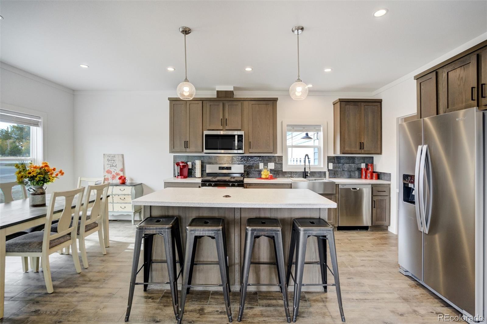 1684 9th Street Limon, CO 80828 - Photo 4 of 39 a kitchen with stainless steel appliances kitchen island granite countertop a dining table chairs stove and refrigerator