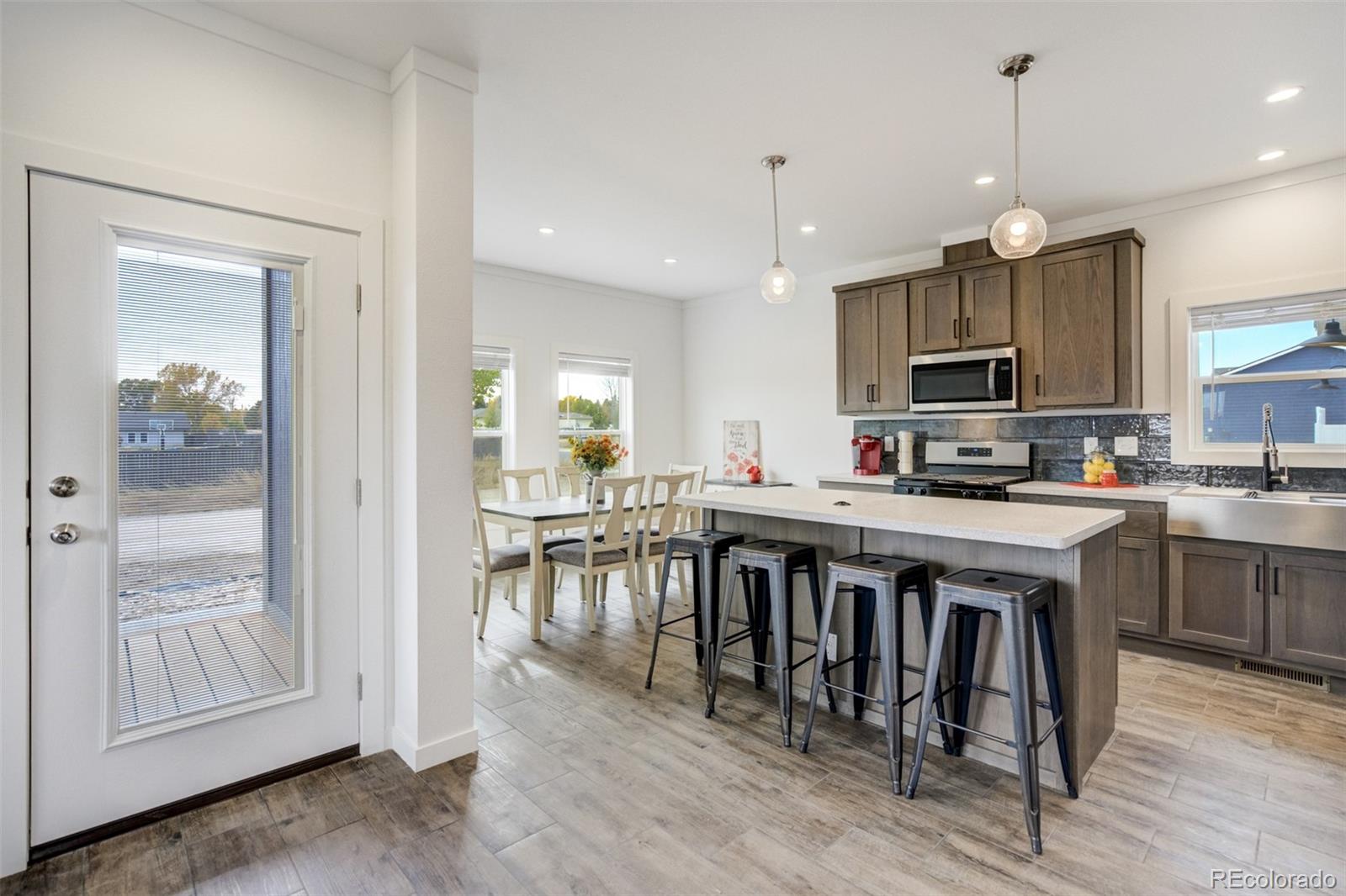 1684 9th Street Limon, CO 80828 - Photo 7 of 39 a kitchen with kitchen island granite countertop a stove a sink a dining table and chairs
