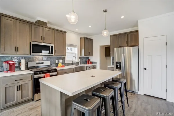 a kitchen that has a table chairs appliances and wooden cabinets