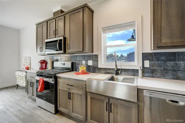 a kitchen with stainless steel appliances granite countertop a sink stove and cabinets