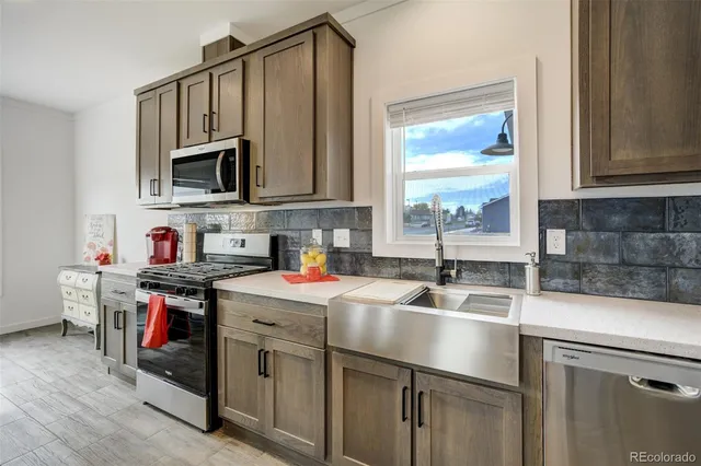 a kitchen with stainless steel appliances granite countertop a sink stove and cabinets