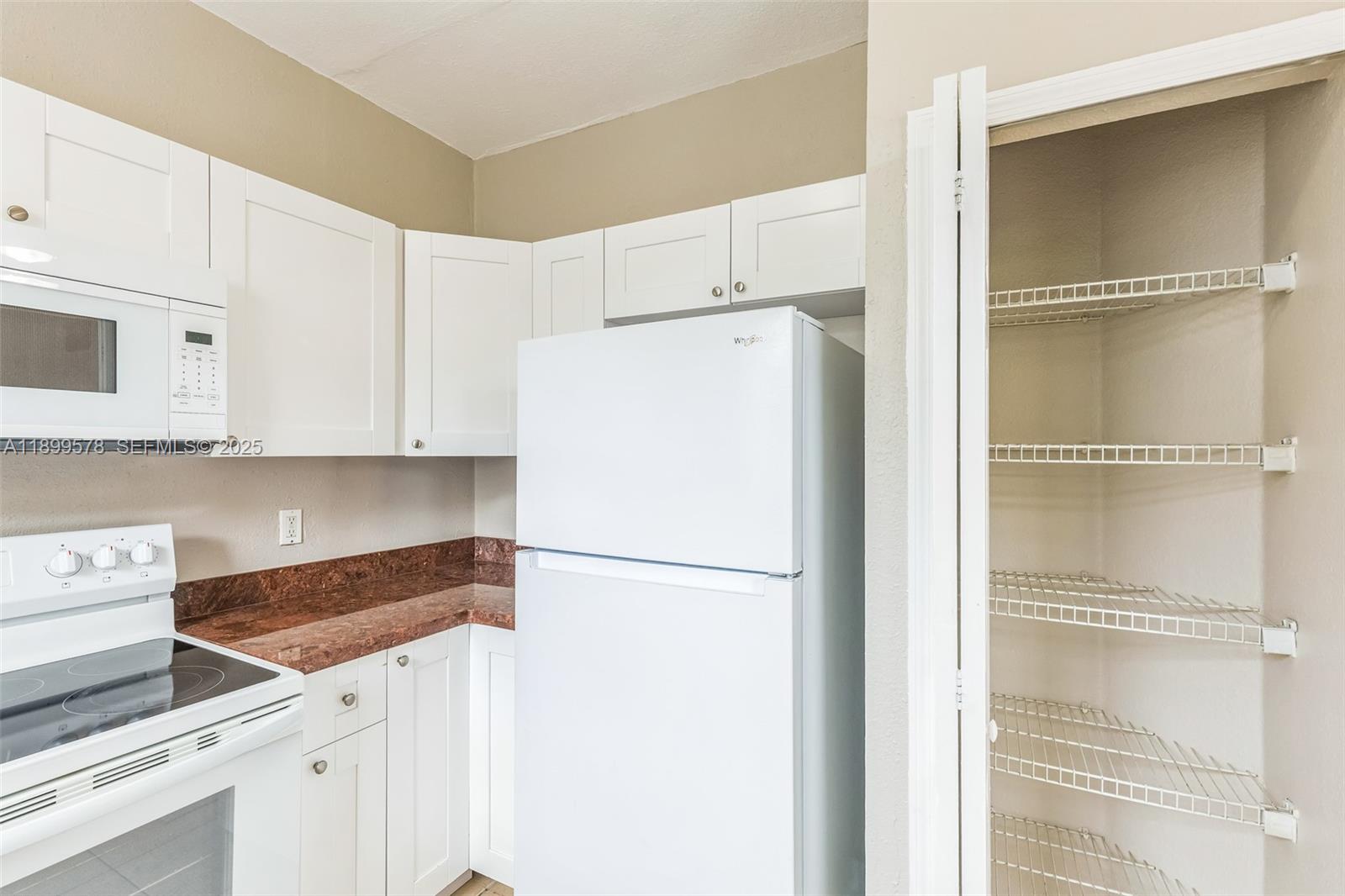 24066 Southwest 109th Court Homestead, FL 33032 - Photo 12 of 37 a kitchen with a refrigerator and a stove top oven