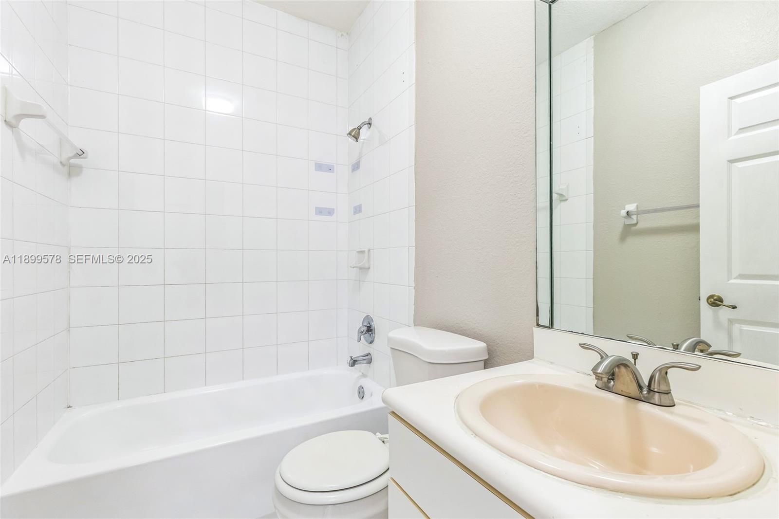 24066 Southwest 109th Court Homestead, FL 33032 - Photo 20 of 37 a bathroom with a bathtub shower sink vanity mirror and toilet and a sink