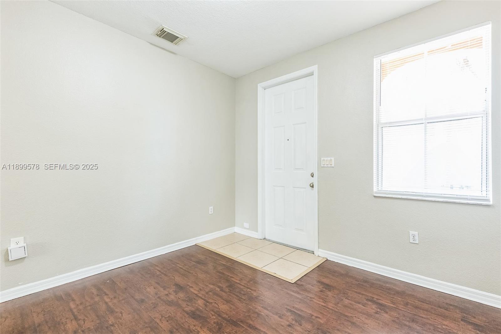 24066 Southwest 109th Court Homestead, FL 33032 - Photo 29 of 37 an empty room with wooden floor and windows