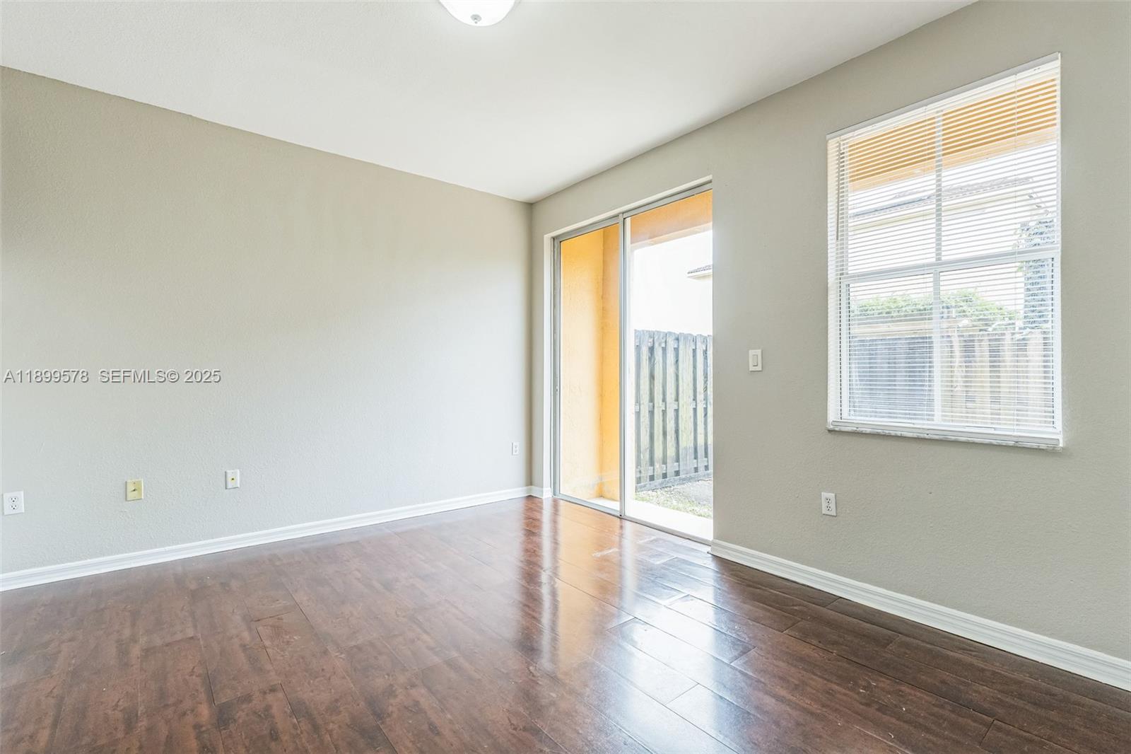 24066 Southwest 109th Court Homestead, FL 33032 - Photo 9 of 37 a view of an empty room with wooden floor and a window