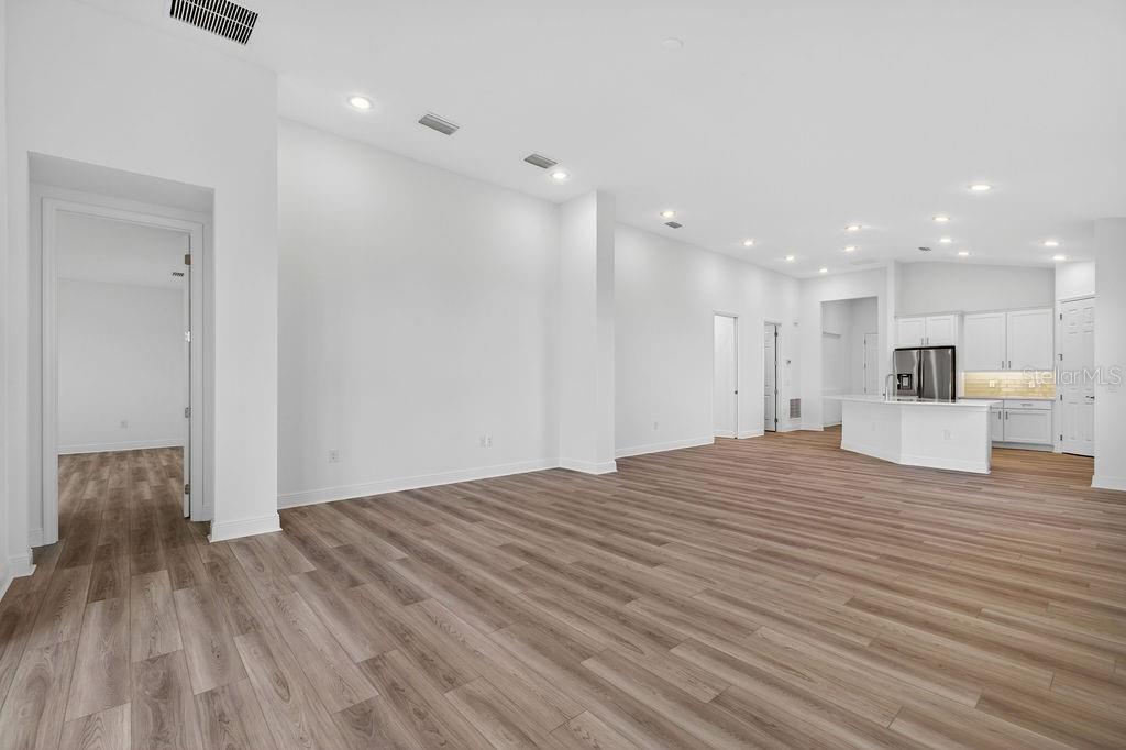3951 Kennebunk Loop Mount Dora, FL 32757 - Photo 11 of 51 a big room with wooden floor and a kitchen view