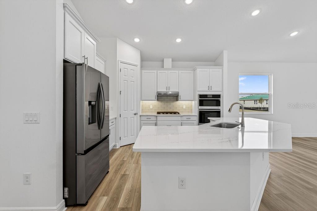 3951 Kennebunk Loop Mount Dora, FL 32757 - Photo 10 of 51 a kitchen with stainless steel appliances a refrigerator sink and cabinets