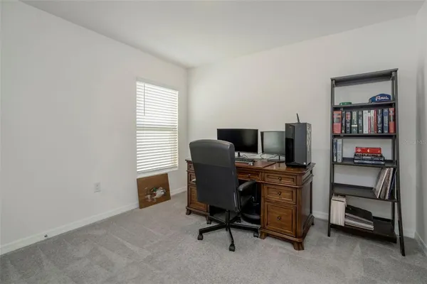 a view of a workspace with furniture and a window