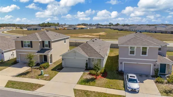 an aerial view of residential houses with outdoor space and ocean view