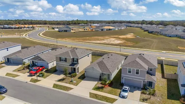 an aerial view of residential houses with outdoor space and ocean view