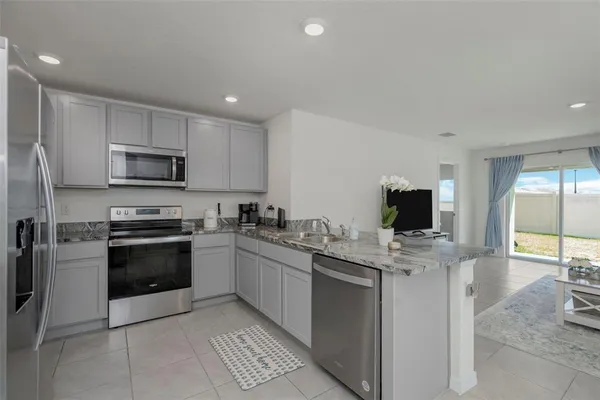 a kitchen with stainless steel appliances a stove a sink and a microwave