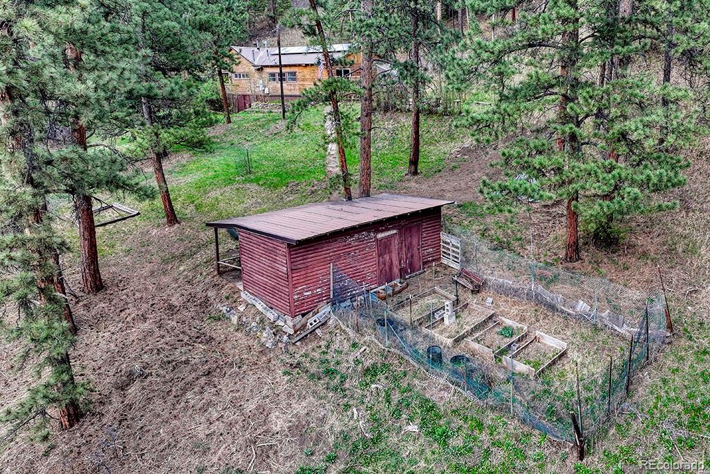 9088 South Murphy Gulch Road Littleton, CO 80127 - Photo 14 of 50 a view of a barn with big yard plants and large trees