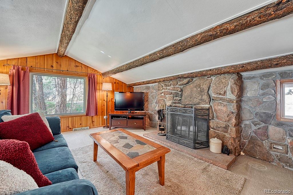 9088 South Murphy Gulch Road Littleton, CO 80127 - Photo 31 of 50 a living room with furniture a flat screen tv and a floor to ceiling window