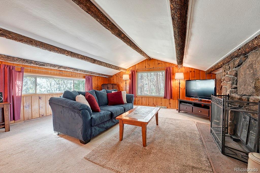 9088 South Murphy Gulch Road Littleton, CO 80127 - Photo 32 of 50 a living room with furniture a flat screen tv and a floor to ceiling window