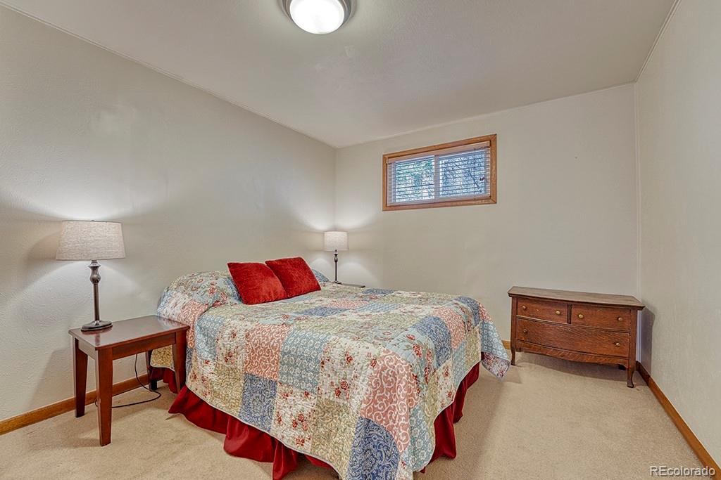 9088 South Murphy Gulch Road Littleton, CO 80127 - Photo 45 of 50 a bedroom with a bed and a lamp