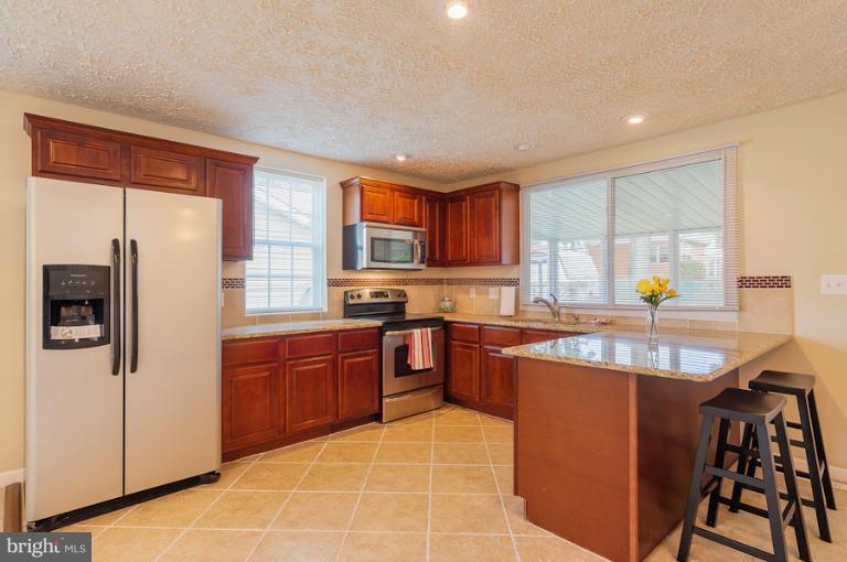 1319 3rd Road Baltimore, MD 21220 - Photo 14 of 29 a kitchen with stainless steel appliances granite countertop a sink counter space cabinets and a large window