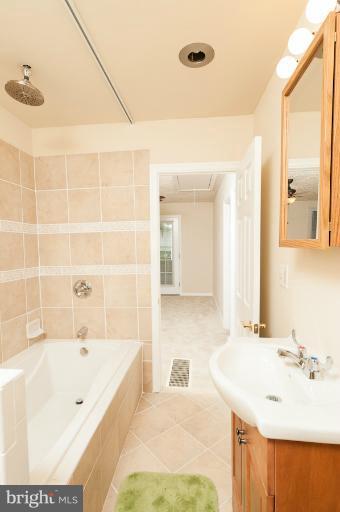 1319 3rd Road Baltimore, MD 21220 - Photo 5 of 29 a bathroom with a tub sink and mirror