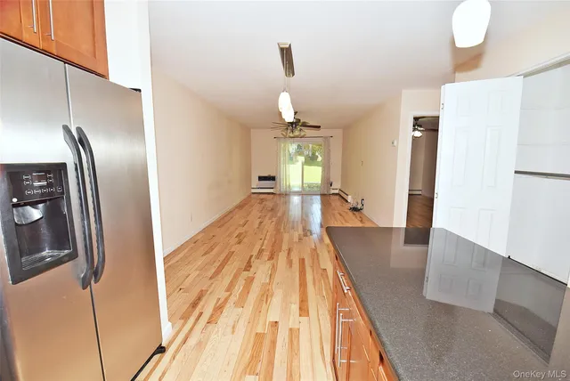 a view of a room with wooden floor and a ceiling fan