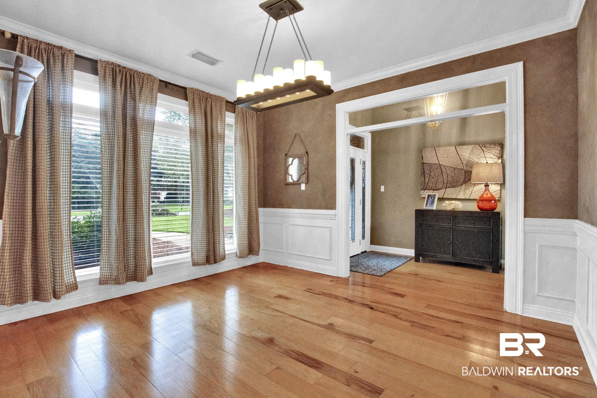 9002 Parliament Circle Daphne, AL 36526 - Photo 12 of 73 hardwood floors and crown molding, wainscoting and a chandelier