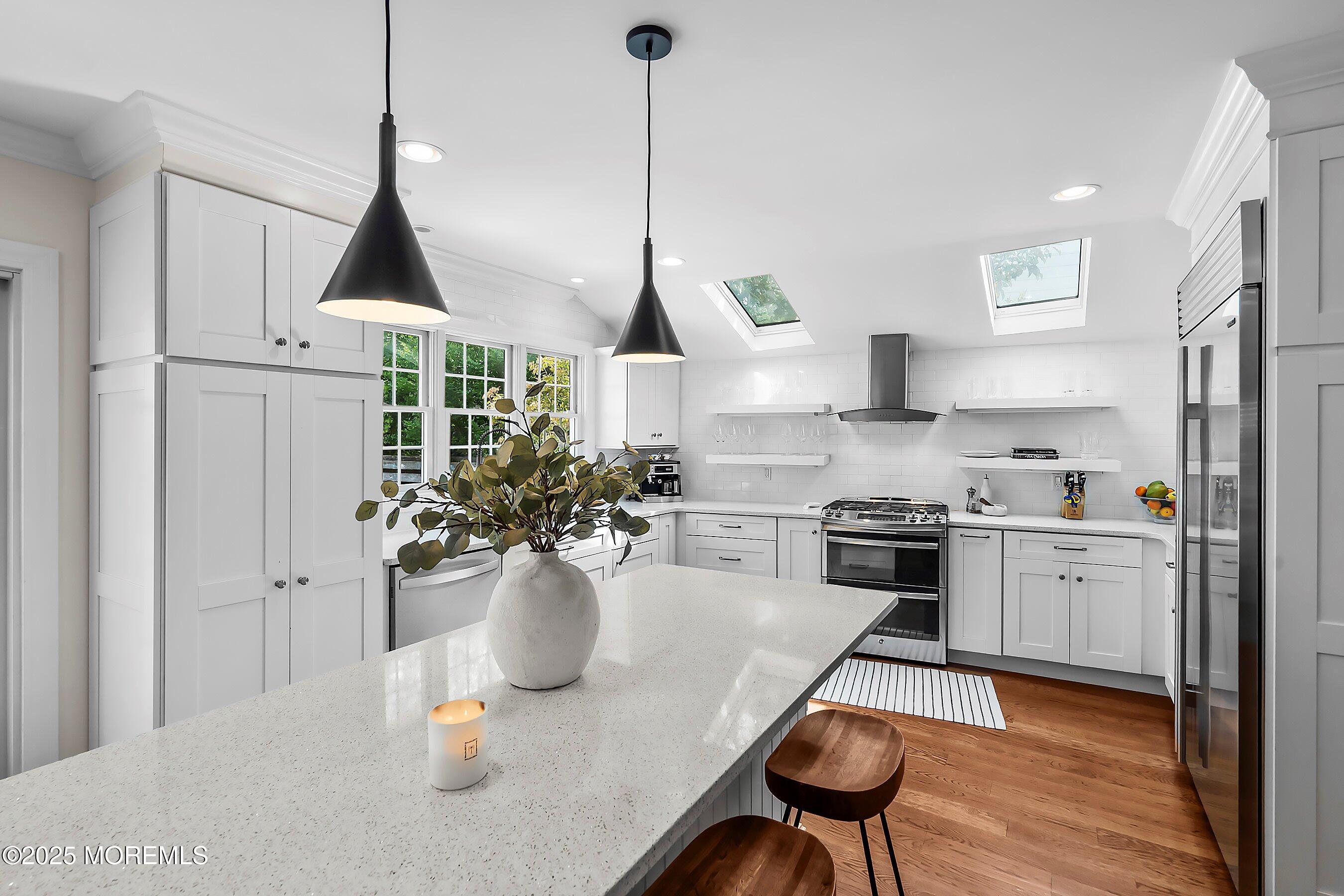 44 Ridge Road Rumson, NJ 07760 - Photo 10 of 38 a kitchen with stainless steel appliances granite countertop a stove a sink a refrigerator a stove a dining table and chairs