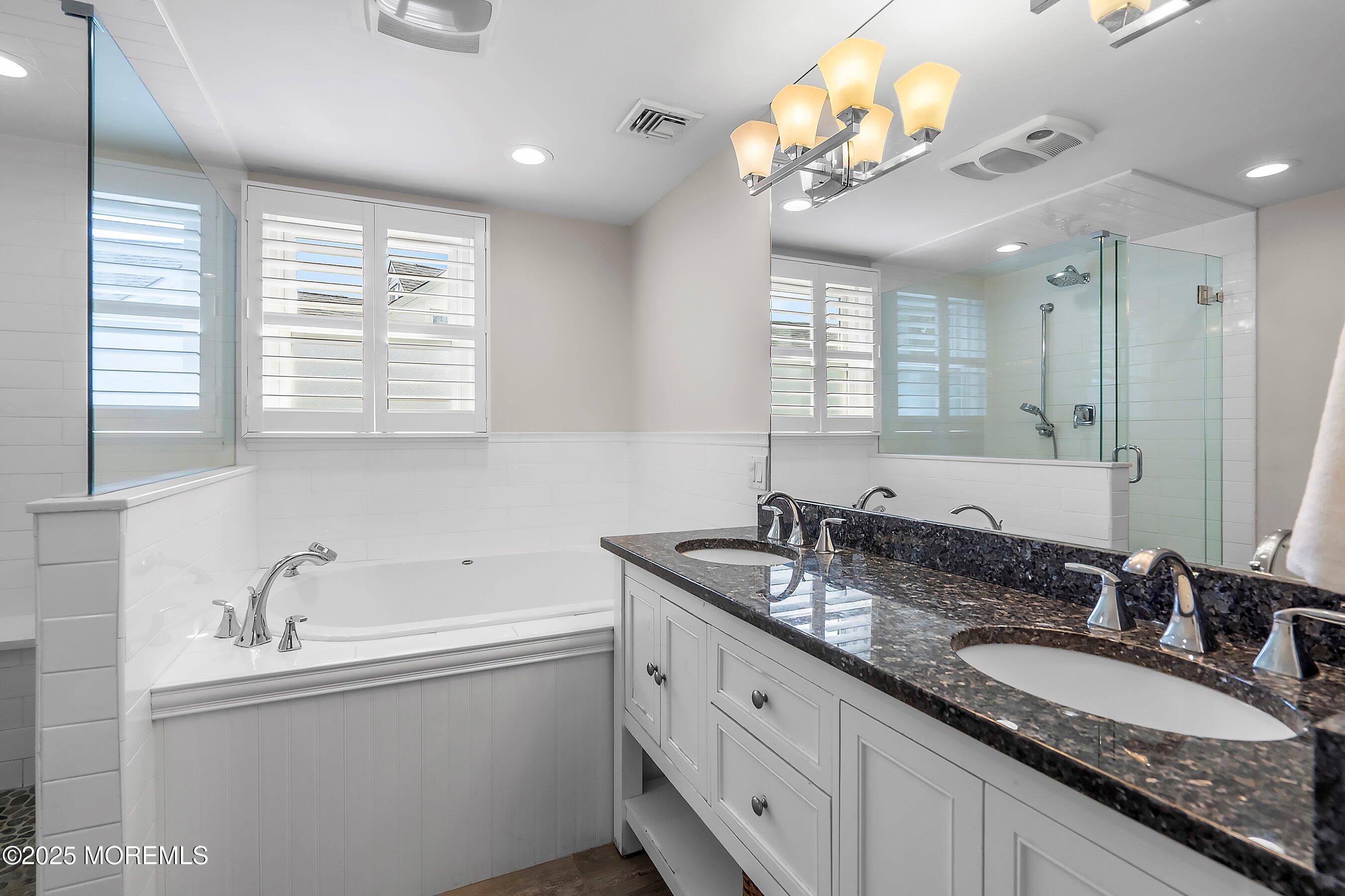 44 Ridge Road Rumson, NJ 07760 - Photo 28 of 38 a bathroom with double vanity sinks a vanity a tub and a large mirror