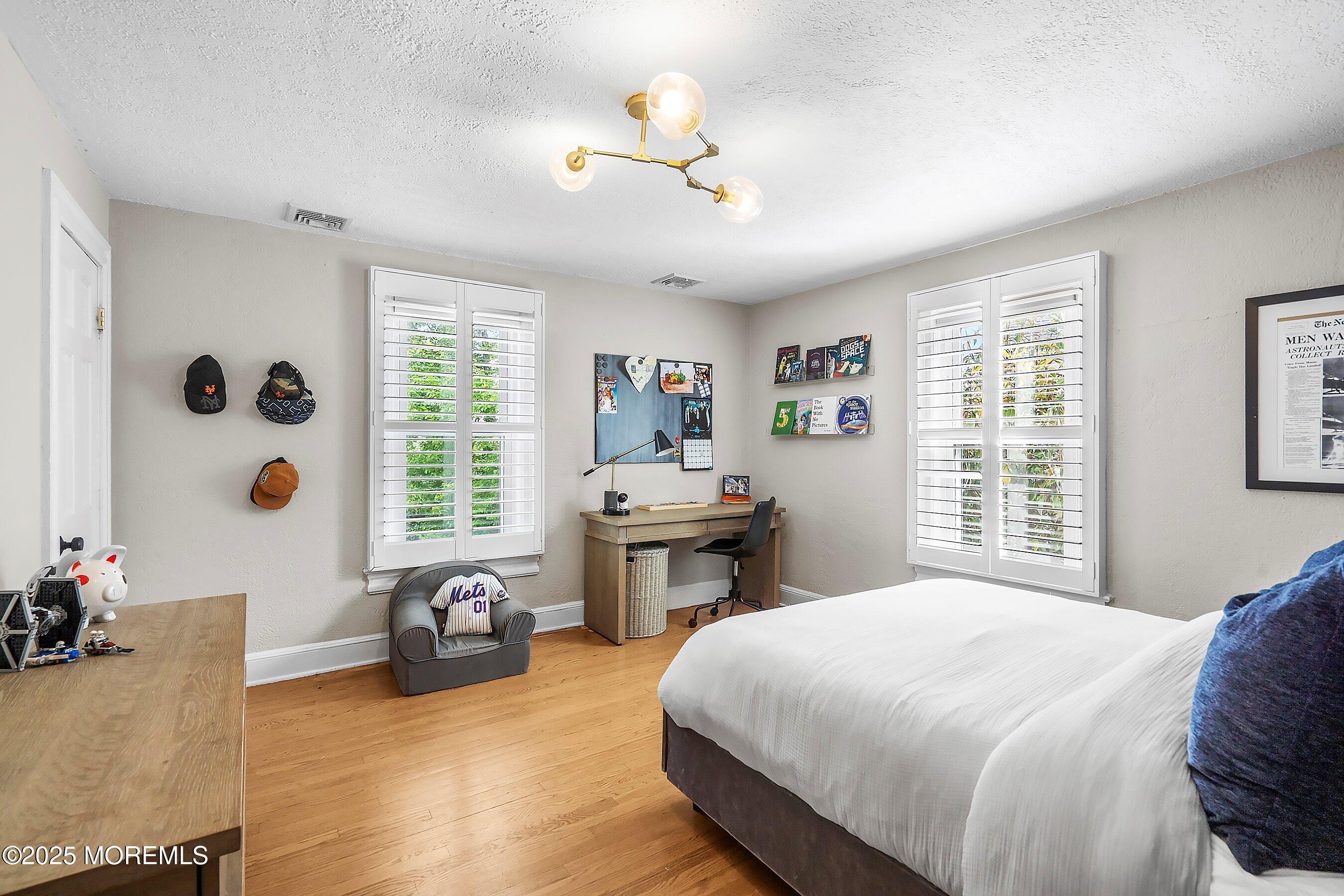 44 Ridge Road Rumson, NJ 07760 - Photo 30 of 38 a bedroom with a bed and a chandelier