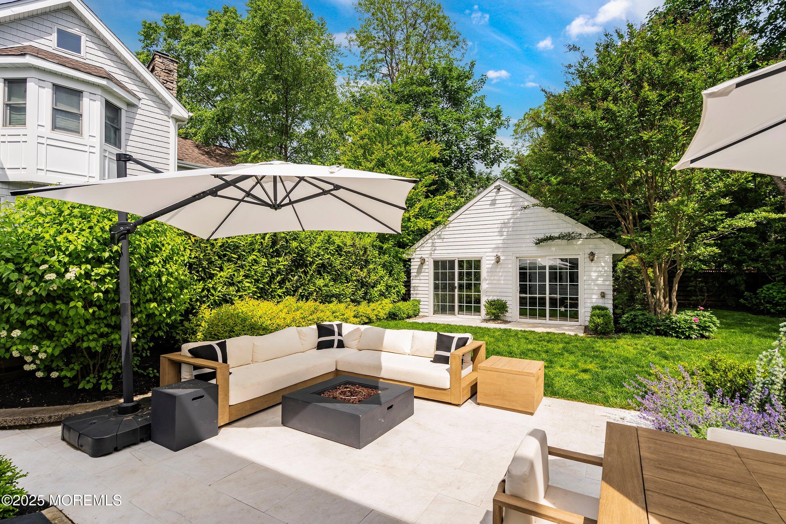 44 Ridge Road Rumson, NJ 07760 - Photo 33 of 38 a view of a patio with couches table and chairs under an umbrella