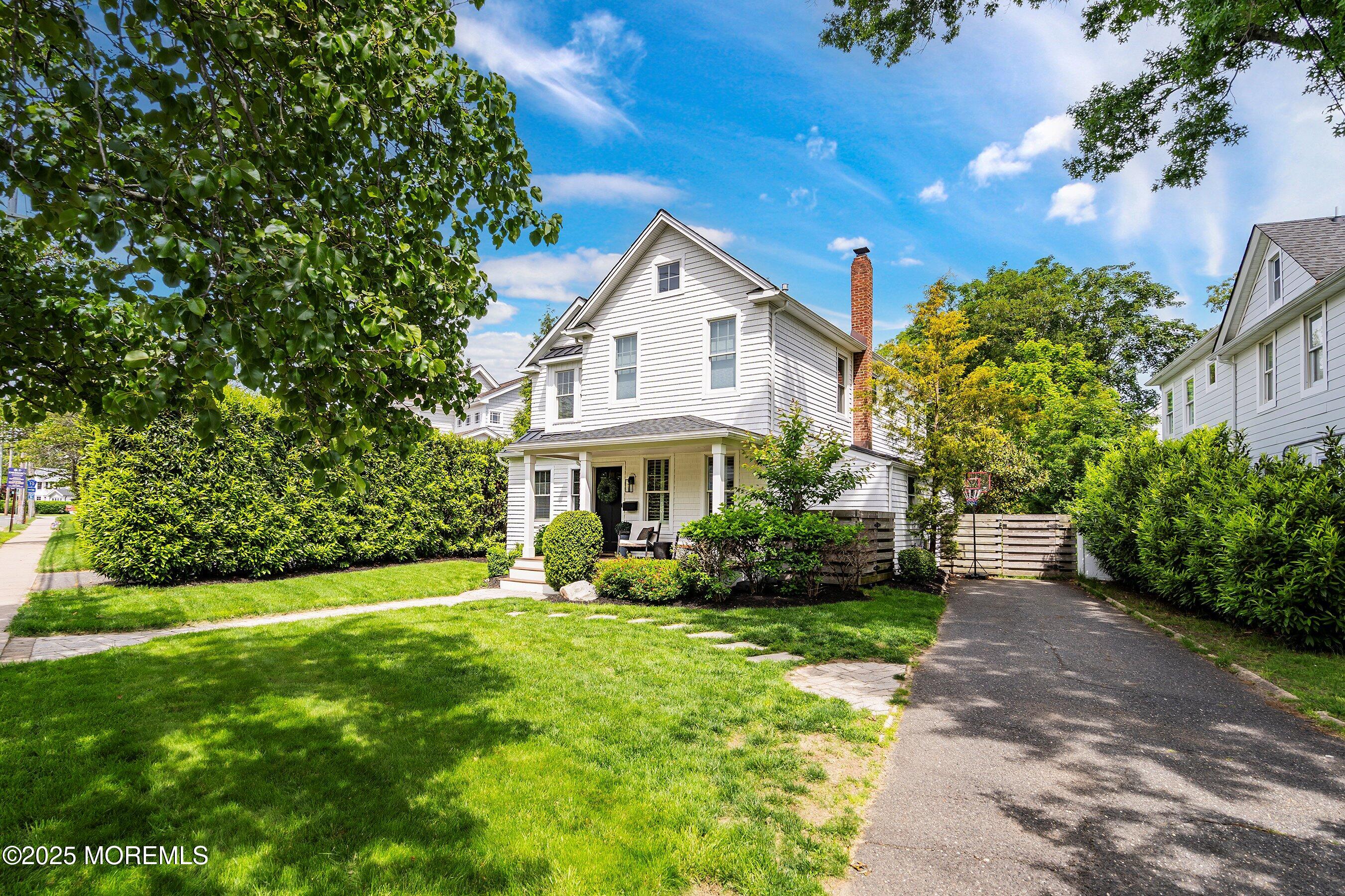 44 Ridge Road Rumson, NJ 07760 - Photo 37 of 38 a front view of a house with a yard and flower plants