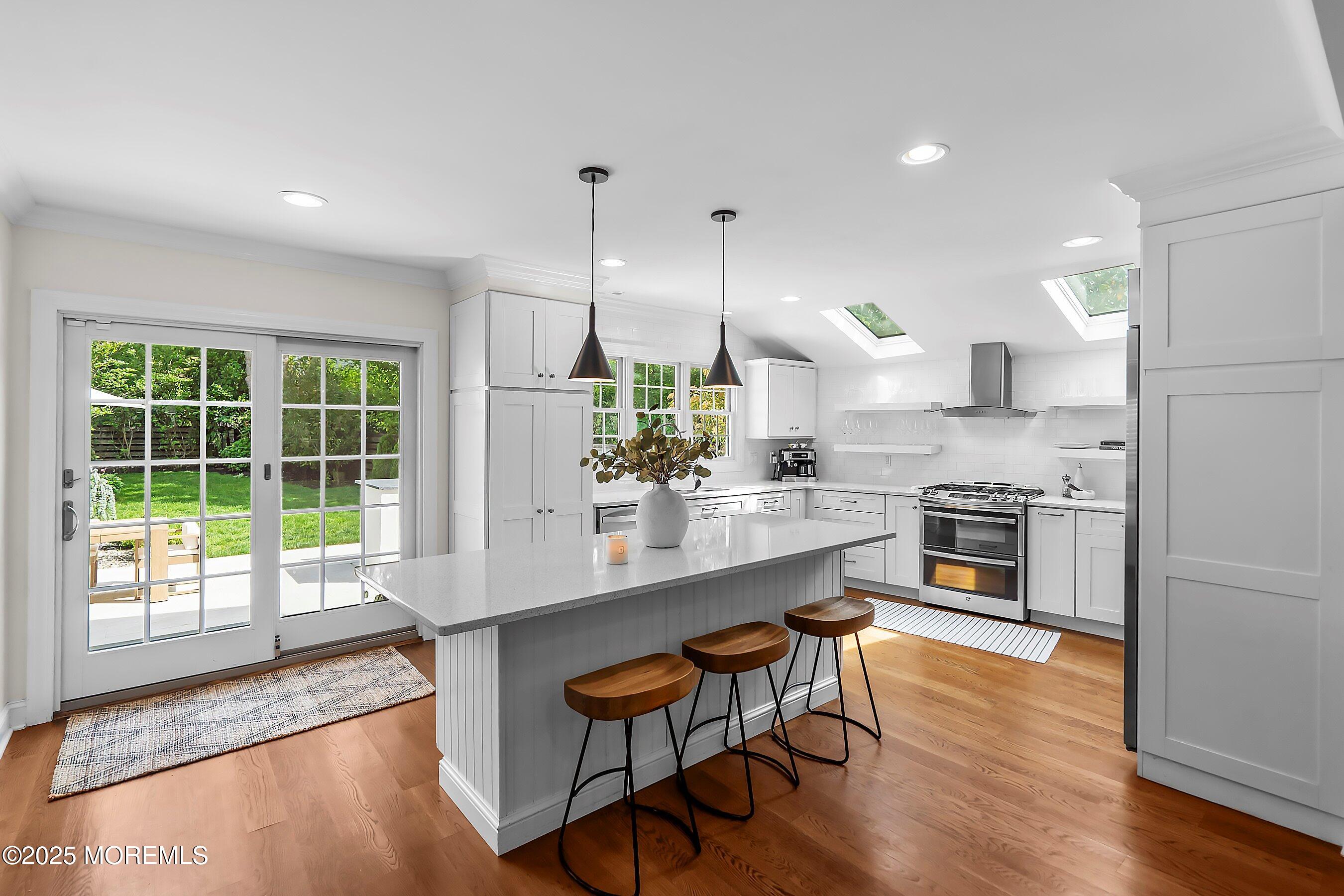44 Ridge Road Rumson, NJ 07760 - Photo 9 of 38 a kitchen with stainless steel appliances granite countertop a stove top oven a sink dishwasher a dining table and chairs with wooden floor