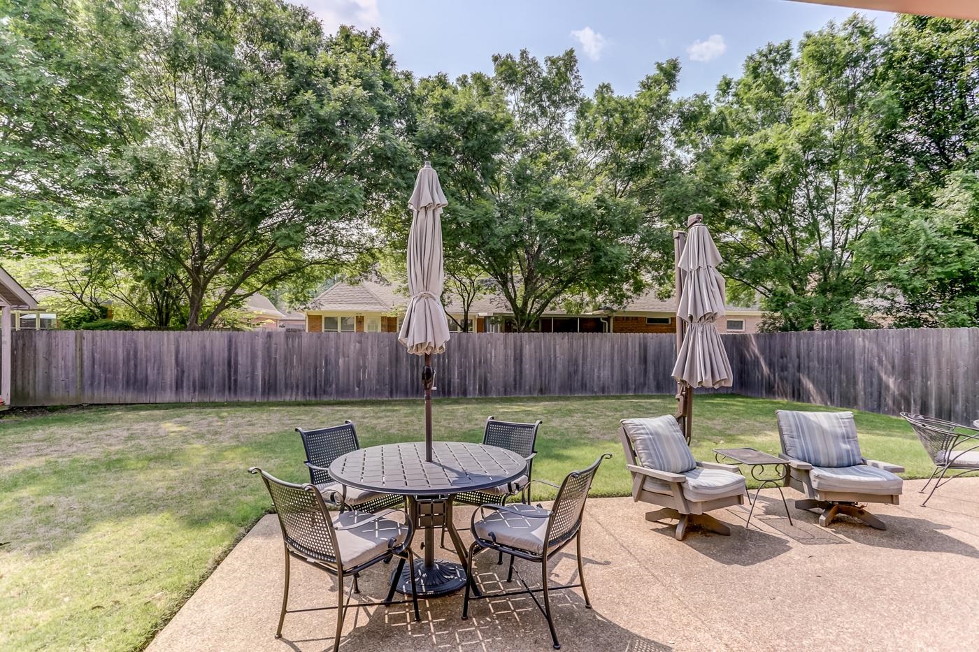 1091 Sugar Lane Collierville, TN 38017 - Photo 24 of 25 a view of a backyard with table and chairs potted plants and wooden fence