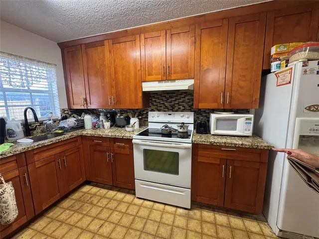 a kitchen with a sink a stove a dining table and chairs