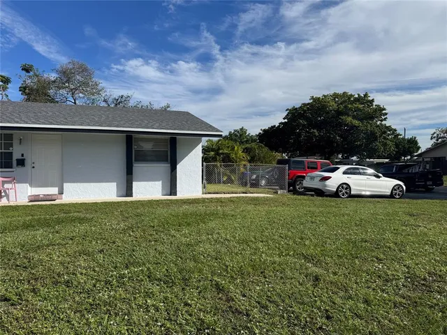 a car parked in front of a house and a yard