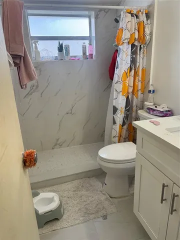 a bathroom with a toilet sink and shower curtain