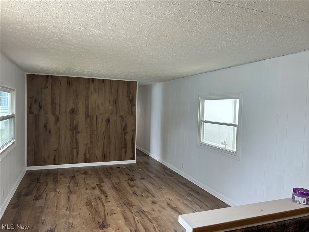 9735 Chillicothe Road, Unit 20 Willoughby, OH 44094 - Photo 5 of 16 Empty living room with a textured ceiling and hardwood / wood-style flooring with a accent w