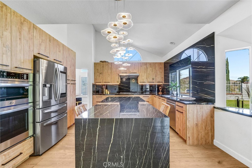 22411 Holly Court Saugus, CA 91390 - Photo 12 of 42 a kitchen with stainless steel appliances a refrigerator sink and stove