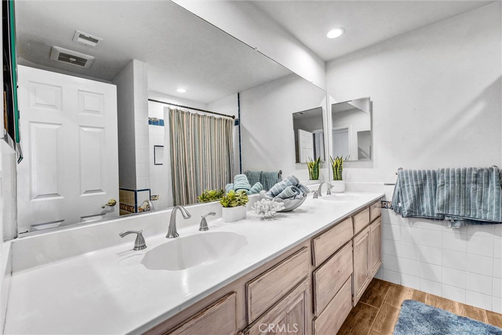 22411 Holly Court Saugus, CA 91390 - Photo 26 of 42 a bathroom with a double vanity sink and a mirror