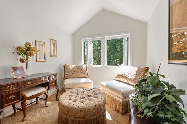 a view of a wooden house with large trees and wooden fence