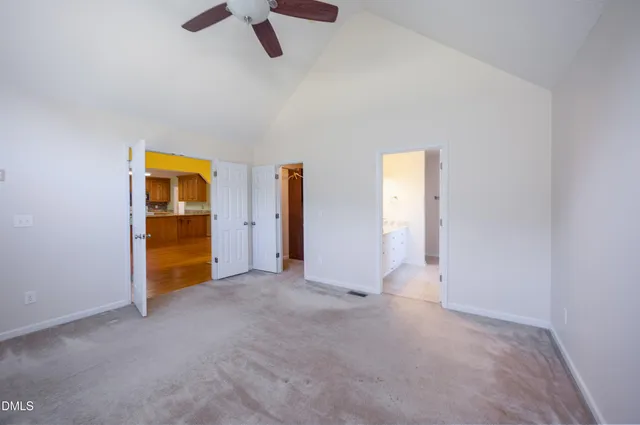 an empty room with closet and windows