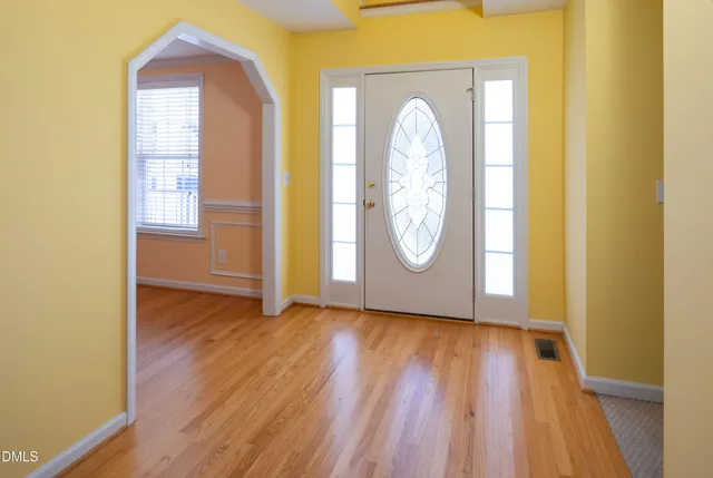 a view of a room with wooden floor and door