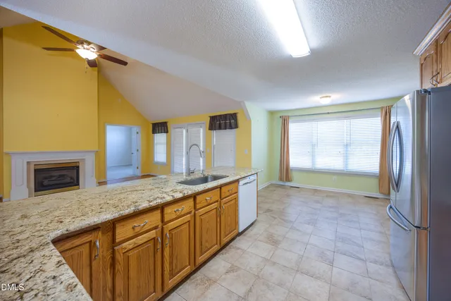 a spacious bathroom with a granite countertop sink a mirror and a bathtub