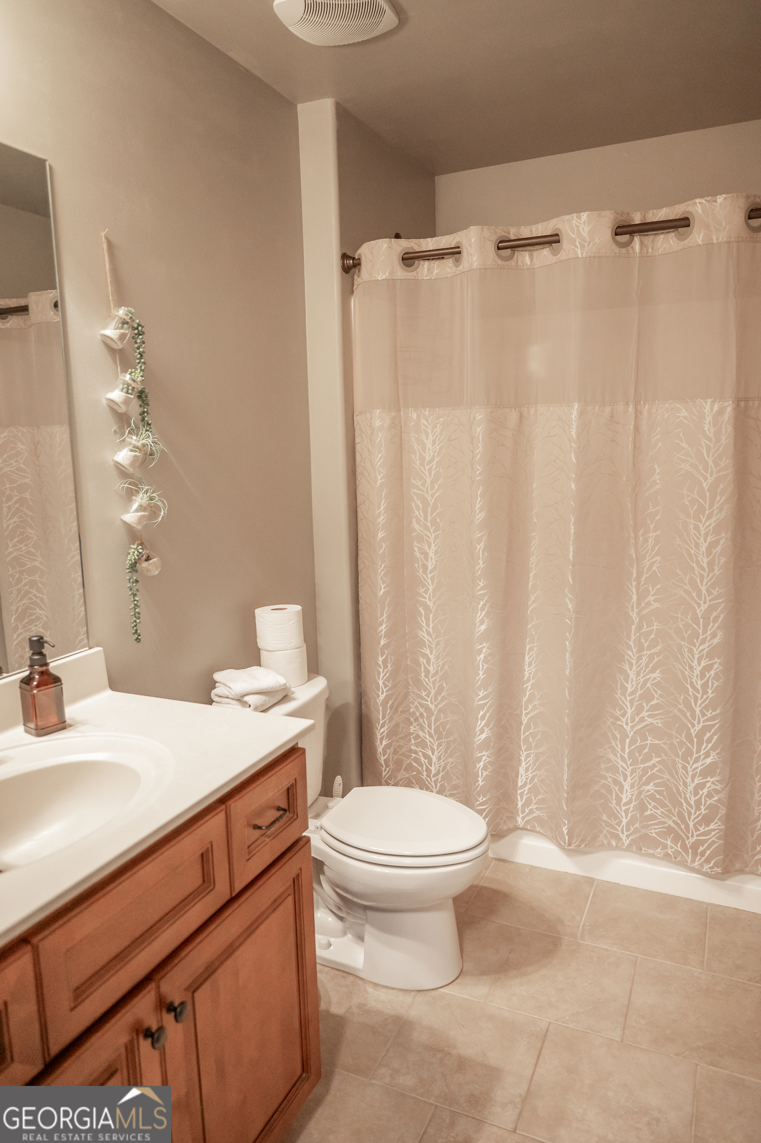 415 EAS Way Fayetteville, GA 30215 - Photo 39 of 70 a bathroom with a sink a toilet a mirror and shower curtain