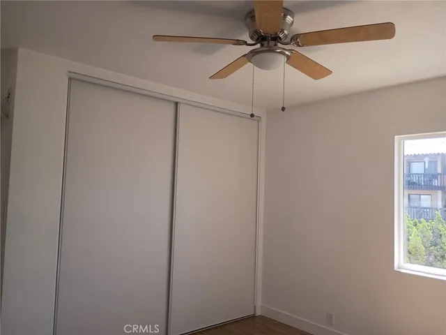 a room view with a ceiling fan and a window