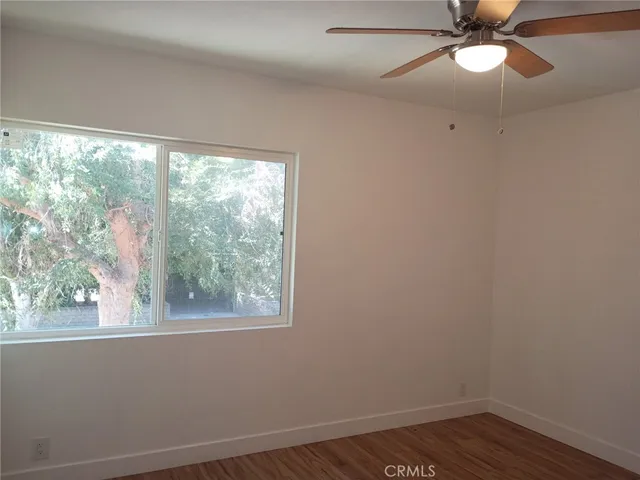 en empty room with wooden floor and windows