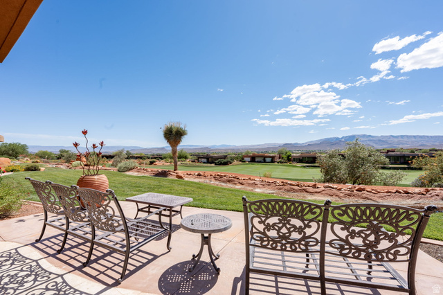 2331 West Entrada Trail, Unit 61 St. George, UT 84770 - Photo 59 of 69 Expansive patio with desert landscaping, a manicured lawn, and distant mountains